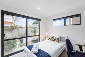 a bedroom with a bed and a large window at Modern 5BR in Mangere - 6 mins from the Airport in Auckland