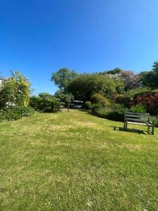 a park with a bench sitting in the grass at Broadmoor Farm in Kilgetty
