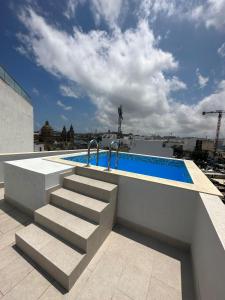 a swimming pool on the roof of a building at KORZO SUITES MSIDA LUXURY PENTHOUSE WITH POOL in Msida