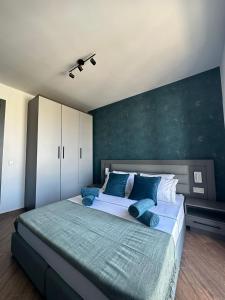 a bedroom with a large bed with blue pillows at KORZO SUITES MSIDA LUXURY PENTHOUSE WITH POOL in Msida