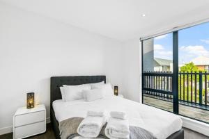 um quarto com uma cama e uma grande janela em 3 Bed Hobsonville Point Enchanter - WiFi - Netflix em Auckland