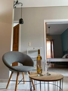 een stoel en een tafel met een fles en wijnglas bij Katerinas Inn Apartments in Kerion