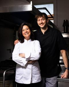 Ein Mann und eine Frau stehen in einer Küche in der Unterkunft Hotel River fronte mare con piscina in Rimini