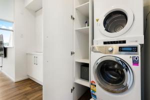 a laundry room with a washer and dryer at The Perfect Pad on the Shore seconds to Stadium in Auckland