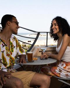 Ein Mann und eine Frau sitzen an einem Tisch in der Unterkunft Hotel River fronte mare con piscina in Rimini