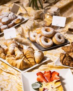 a table topped with different types of pastries and bread at Hotel River fronte mare con piscina in Rimini
