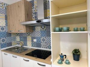 a kitchen with blue and white tiles on the wall at BlueSun Apartments in Leporano Marina