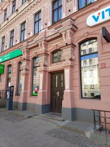 a pink building with a door on a street at Centrally located Studio apartment in Rīga