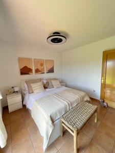 Villa Aloe في لاجاريس: غرفة نوم فيها سرير ومقعد