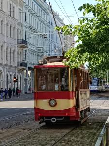 a red and yellow trolley car on a city street at Centrally located Studio Apartment in Riga +26 photos