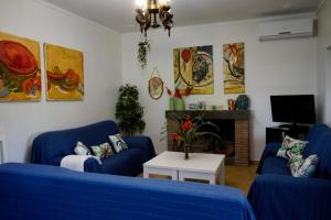 sala de estar con 2 sofás azules y chimenea en HACIENDA SAN FRANCISCO, en Prado del Rey