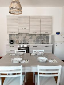 マリッティマにあるCasa Marittimaのキッチン(木製テーブル、白い椅子付)
