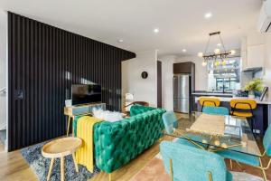 a living room with a green couch and chairs at 3 Bedroom Stunner in Hobsonville - WiFi - Netflix in Auckland