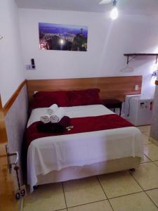 a bedroom with a bed with a red and white blanket at Pousada Solar de Lourdes in Guarapari +22 photos