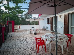 une terrasse avec une table, des chaises et un parasol dans l'établissement Villa Nel Verde - Bonsignore, à Tricase