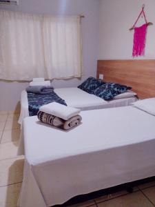 duas camas num quarto com toalhas em Pousada Solar de Lourdes em Guarapari