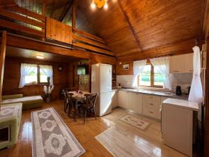 a kitchen with a white refrigerator and a table at Cabana MADLUK in Arieşu de Pădure