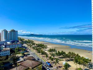 Una vista de una playa con palmeras y el océano. en Residencial João Orisaka, en Samaritá