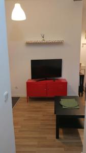 a living room with a red cabinet with a flat screen tv at El pisito de Malasaña in Madrid