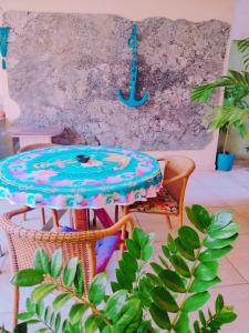 a table and chairs in a room with a wall at Pousada Solar de Lourdes in Guarapari