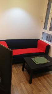 a red and black couch in a room with a table at El pisito de Malasaña in Madrid