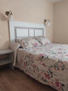 a bedroom with a bed with a floral bedspread at Hotel Rural Cabrales in Carreña de Cabrales 