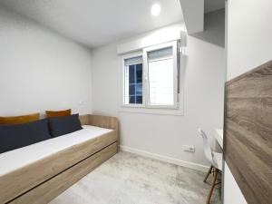 a small bedroom with a bed and a window at 1 Piso 2 habitaciones centro al lado de Príncipe in Vigo