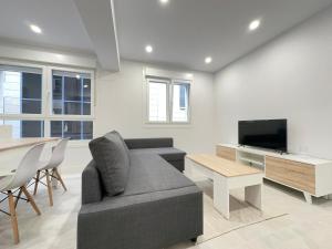 sala de estar con sofá, mesa y TV en 1 Piso 2 habitaciones centro al lado de Príncipe, en Vigo
