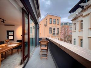 einen Balkon mit einer Bar, einem Tisch und Stühlen in der Unterkunft Homie Suites - Modern Apartments Nearby Istıklal Street & Galata Tower in Istanbul