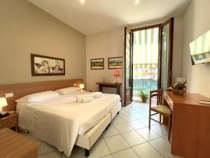 a bedroom with a bed and a desk and a window at Hotel Leopolda in Florence