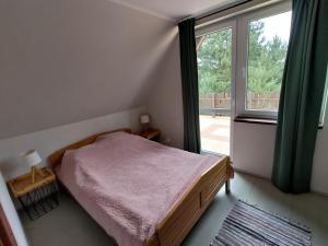 ein Schlafzimmer mit einem Bett und einem großen Fenster in der Unterkunft Dom domek na Mazurach Jezioro Sasek Wielki Trelkówko Szczytno 1 in Kobyłocha