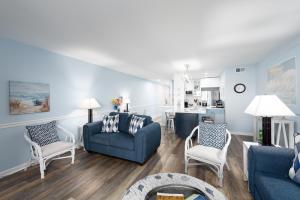 a living room with a blue couch and chairs at 1305 Pelican Watch Villa in Seabrook Island +19 photos