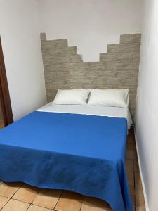 a bed with a blue blanket on top of it at Ginevra house in Naples