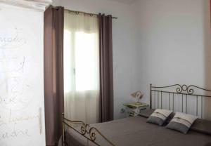 Un dormitorio con una cama grande y una ventana en Sunrise Apartment en Castelsardo