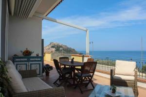 a patio with a table and chairs and a view of the ocean at Sunrise Apartment in Castelsardo