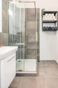 a bathroom with a shower with a sink and a counter at Cozy 2-Raumwohnung in Zentrumsnähe in Leipzig