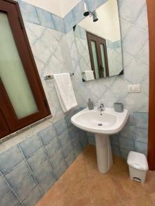 a bathroom with a sink and a mirror at Sunrise Apartment in Castelsardo