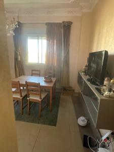 a dining room with a table and a television at Appartement tanger Beach in Tangier