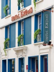 un hôtel à Londres avec des fenêtres bleues et un panneau d'affichage dans l'établissement Hôtel Exquis, à Paris