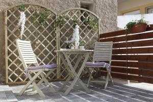 2 sedie e un tavolo su un patio di inHeart Apartment Chios a Chio (Chios)