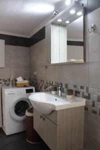 a bathroom with a sink and a washing machine at inHeart Apartment Chios in Chios +18 photos