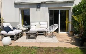 a patio with two chairs and a couch and a table at Chambre privée avec SDB attenante in Vertou
