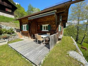 Cabaña de madera con mesa en una terraza de madera en Alpenchalet Piz Hüsli, en Tschagguns