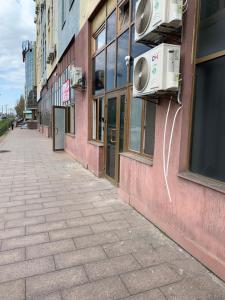 an empty sidewalk next to a pink building at Mega city in Kyiv