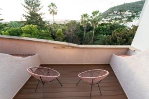 two pink chairs sitting on a balcony with a view at Hotel Taburiente S.C.Tenerife in Santa Cruz de Tenerife
