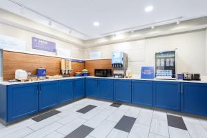 a store with blue cabinets in a large room at Holiday Inn Express & Suites Williamsburg, an IHG Hotel in Williamsburg