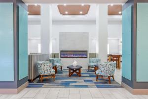 a waiting room with chairs and a fireplace at Holiday Inn Express & Suites Williamsburg by IHG in Williamsburg