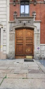 a large wooden door on the side of a building at Cenacolo Apartment in Milan