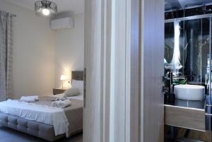 a white bedroom with a bed and a bathroom at Kallithea Guesthouse in Nydri