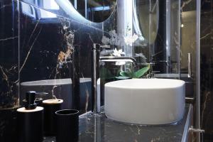 a black bathroom with a white sink and a tub at Kallithea Guesthouse in Nydri +6 photos